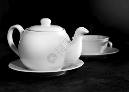 新鲜的咖啡店白瓷茶杯和壶下午桌布置黑白图片