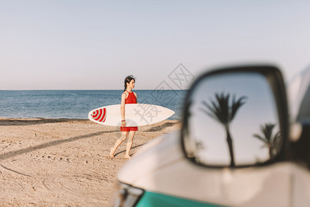 年轻女孩在沙滩上冲浪板图片
