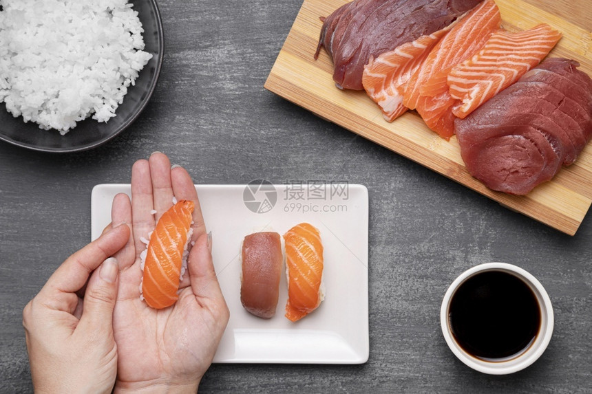 小吃白色的紧双手准备寿司生的图片
