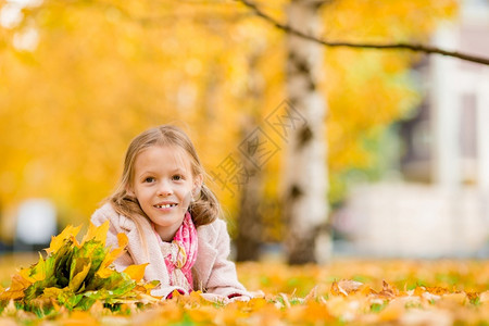 撑树叶女孩秋天在公园玩乐的小女孩背景