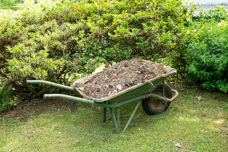 花园废料农业花园艺工具上填满土壤或堆肥的轮轴家关心背景