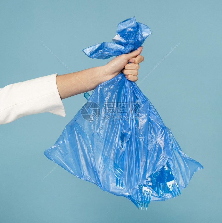 厨房拥有蓝色塑料垃圾袋的妇女高清晰度照片持有蓝色塑料垃圾袋的照片高质量品蓝色的常设图片