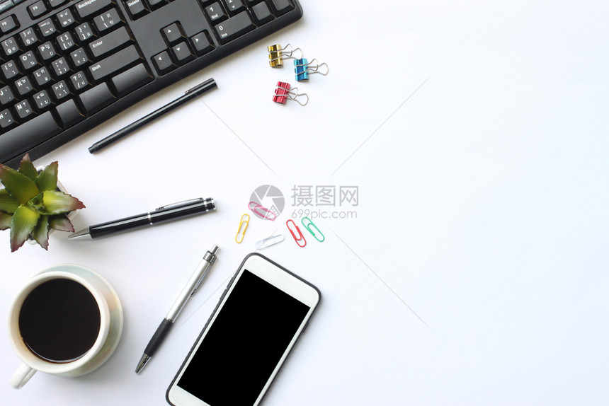 平坦的键盘智能手机笔记本茶咖啡笔和用品放在办公室白桌上并有供设计使用的复制空间工作场所补给品图片