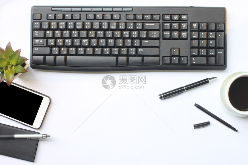 补给品电话键盘智能手机笔记本茶咖啡笔和用品放在办公室白桌上并有供设计使用的复制空间最佳图片