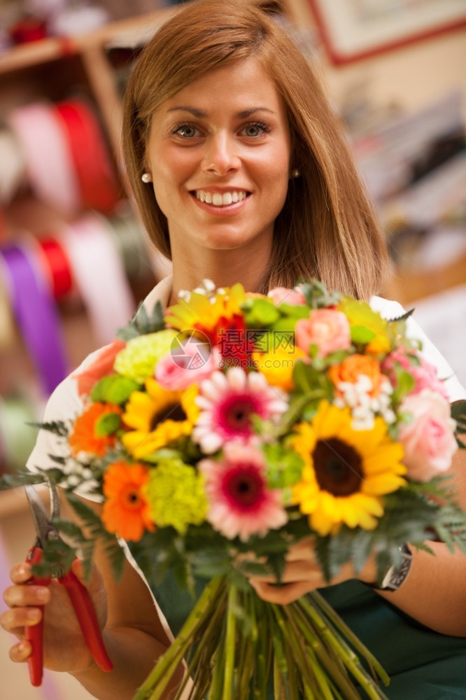 销售人们棕褐色的花店家正在制作一束色彩多的花绿色图片