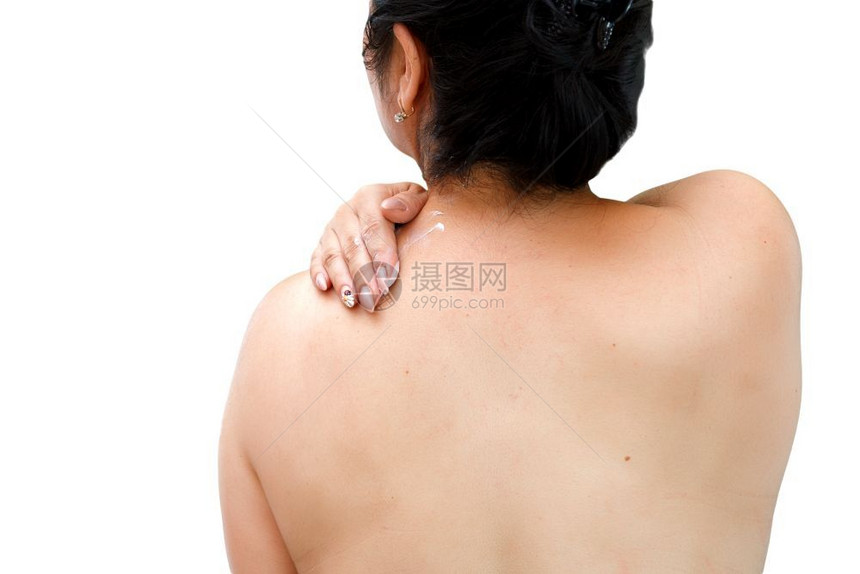 在颈部和肩膀上涂保湿霜的女性图片