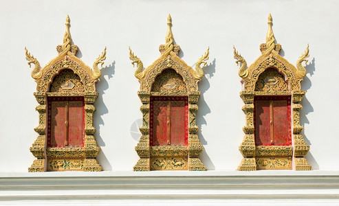 寺庙复古的白色混凝土墙上金的窗框用庙泰风格装饰图案红色的图片