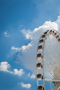 公园白色大发轮蓝天空尖云彩背景的白羽轮复古狂欢图片