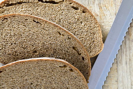 屑团体从面粉上真正的黑包中切成一片黑面包的暗大麦图片