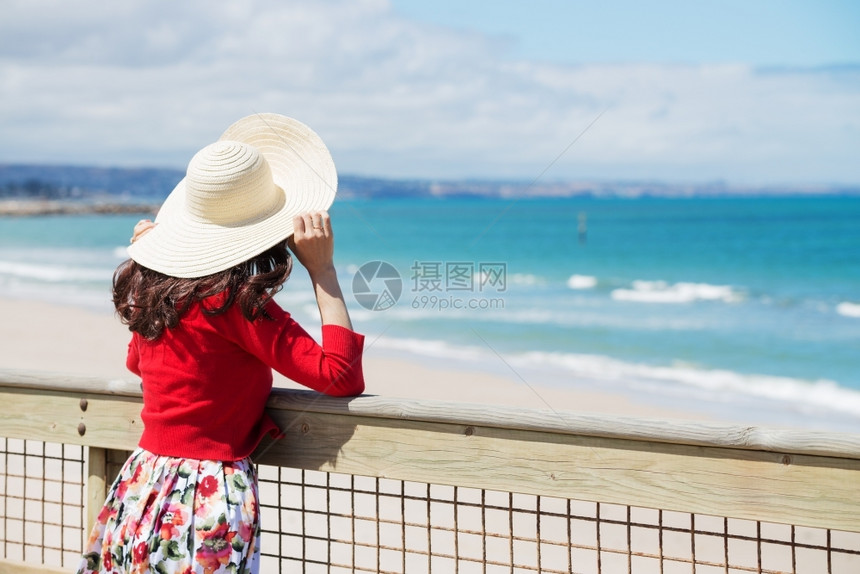 身着红脸的美女仰望着大海热的自然步行图片