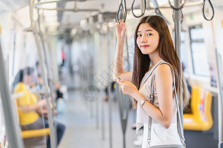 乘坐地铁看手机的年轻女孩图片