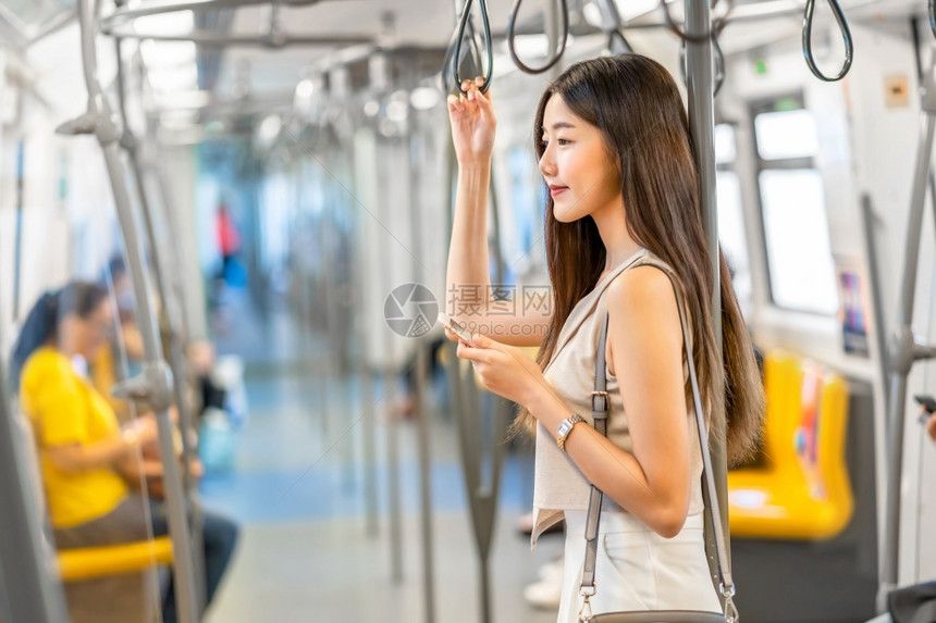 乘坐地铁看手机的年轻女孩图片