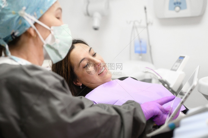 给女病人看x光片的牙医图片