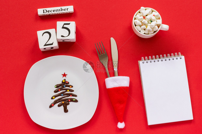 十二月杯子125日圣诞成份甜巧克力圣诞树在盘子上圣塔帽餐具和加棉花糖的可杯红色背景纸上的条是空平铺假装圣诞成份12月5日圣诞节图片