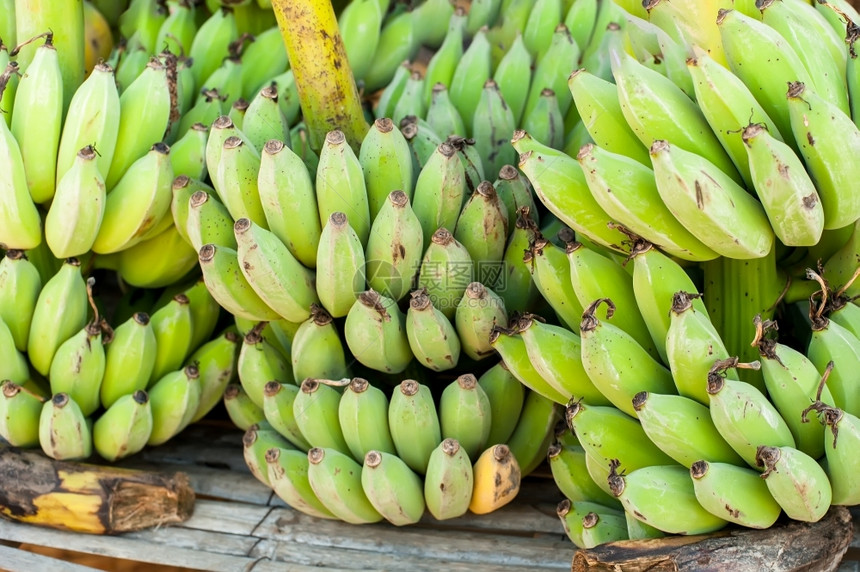 亚洲人甜的新鲜有机香蕉在户外亚述市场销售的有机香蕉图片