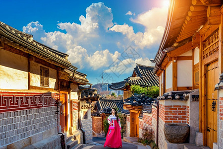 穿着韩国传统汉式建筑的漂亮女孩在韩国首尔KoreaBukchonHanok村传统韩国风格建筑城市传统的裙子背景图片