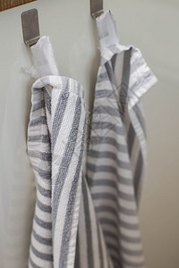 卫生餐巾衣架两条厨房毛巾挂在的钩上特写现代两条厨房毛巾挂在的钩上特写图片