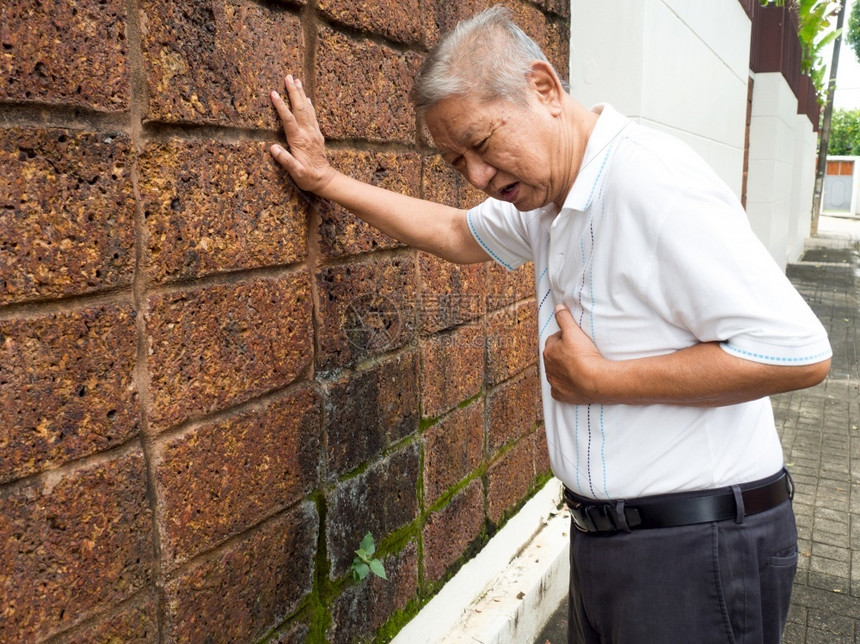 高年男子胸前疼痛且因心肌梗塞而抱住乳房的心脏病发作概念药物关心患病的图片