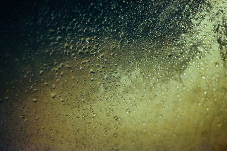 雨滴夜晚黄昏和bokeh灯光下车边玻璃上的水滴雨图片