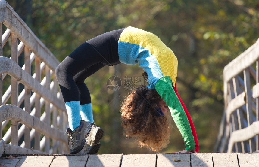 放松常设嬉戏的美丽女孩在秋天公园做伸展运动图片