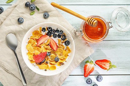 牛奶平躺在浅健康早餐中玉米片浆果和白木桌上的蜂蜜美味一顿饭图片