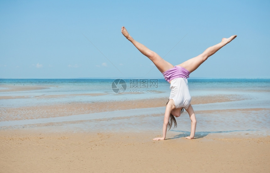 沙滩上倒立的年轻女子图片