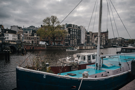 阿姆斯特尔丹码头和停泊在欧洲房屋上的子停泊船只背景晚上桥图片