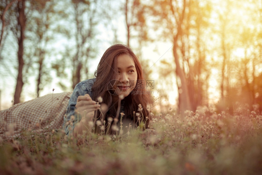 年轻的亚洲女人在秋天公园的摄像头面前摆姿势吸引人的幸福温暖图片