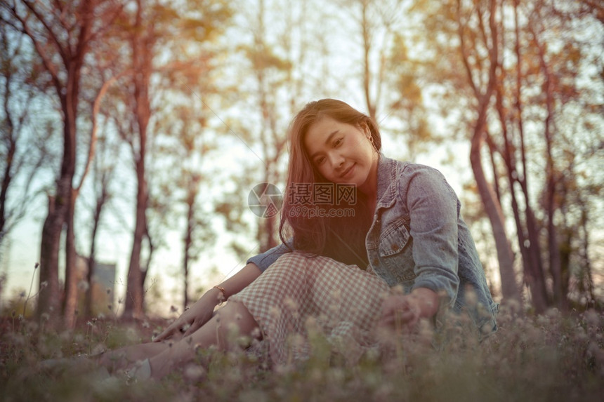 女士吸引人的年轻亚洲女人在秋天公园的摄像头面前摆姿势树叶图片