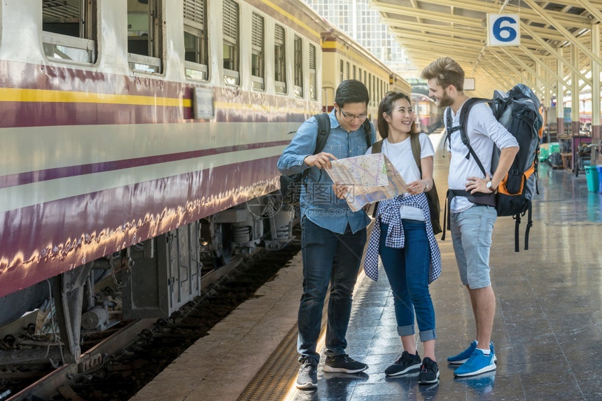 多族裔游民正在火车站看在站持有带幸福行动的旅和交通概念旅游和交通的观念保持步行独自的图片