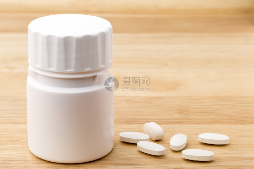 木制的桌背景上白色药丸瓶木桌背景上的白色药丸瓶科学麻醉剂图片