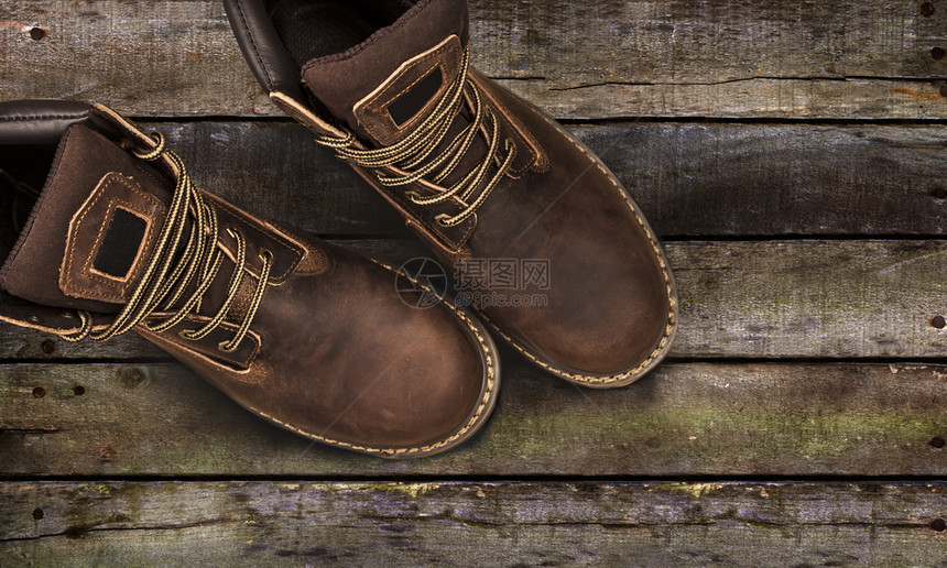 布朗芒高斯靴子用木制背景查封与世隔绝的布朗芒高斯靴子用木制背景棕色的白领带图片