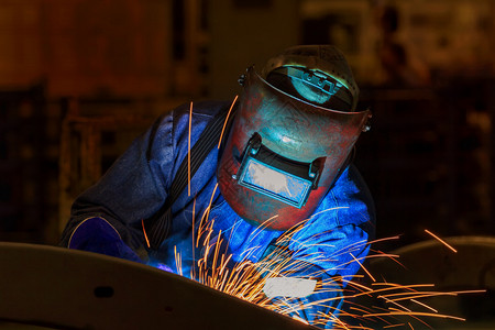 在工厂中焊接汽车部件的防罩工人与汽车部分焊接使固定连安全图片