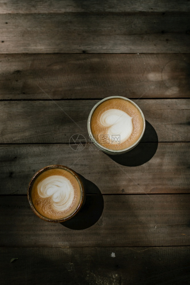 有选择焦点杯用木制桌上的热拿铁艺术咖啡重点放在白泡沫杯加热拿铁艺术咖啡杯子心品尝图片