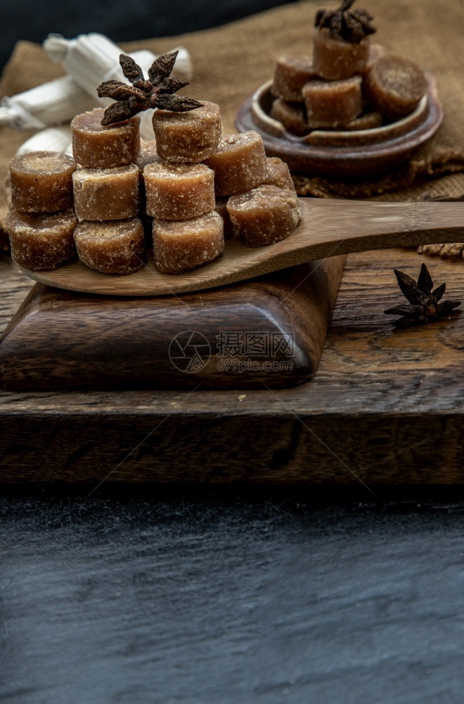 饮食黑色的可选择棕甘蔗糖方块放在木板和麻布上图片
