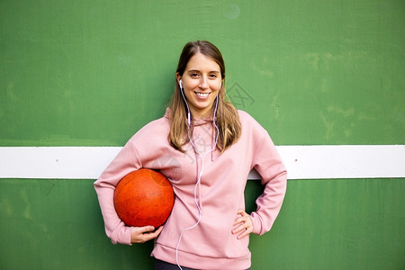 长头发的年轻女孩拿着篮球挡绿墙青少年活动漂亮的图片