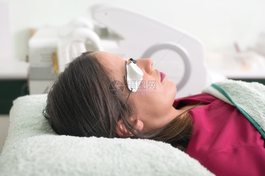 在美容院躺着做眼部治疗的女性图片
