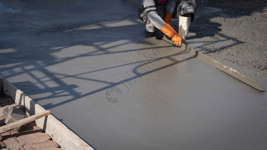 使用建筑工地板上石膏水泥的长三角形土绘制亚洲建筑工人的作物图象在建筑工具体的地面保护背景图片