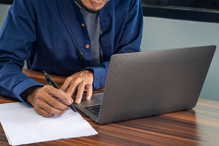 电脑分层素材签约手以计算机笔记本在办公室工作商在家庭办公室作人在家等文件写的男子应用背景