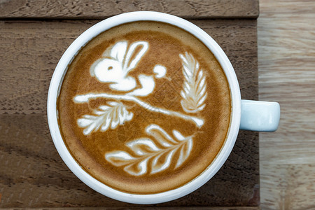 咖啡制品热的优质一杯咖啡加拿铁美食菜单向兔子展示木桌背景饮品和艺术概念的树木和叶子一种设计图片