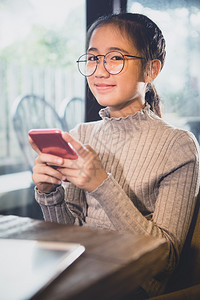 细胞脸连接手拿着智能机笑面微的亚洲青少年图片