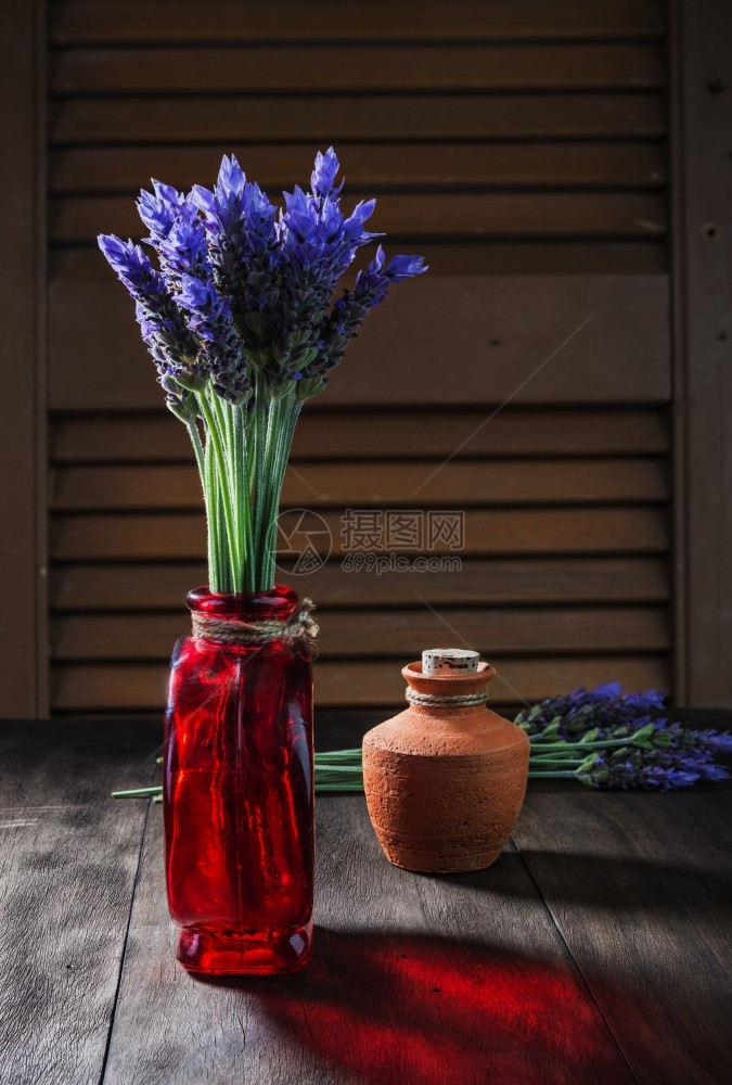 失眠植物开花瓶和陶瓷锅中用旧木本底含油的古代花瓶和陶瓷锅中的熏衣花束图片