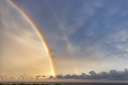 风景优美在大海雨后闪耀着两条彩虹云绿色图片