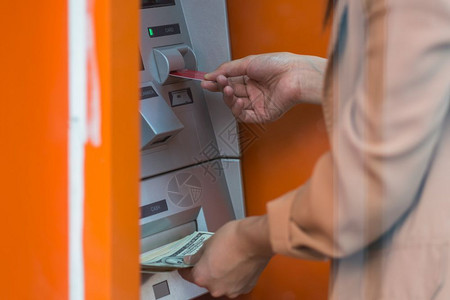 妇女通过自动取款机商业自动取款机提现金自动款机概念微笑自动的银行图片