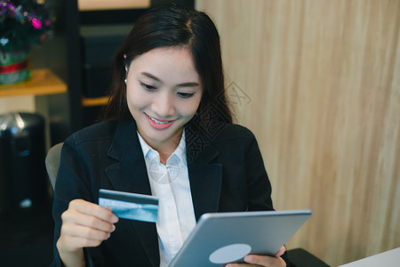 在线使用平板牌和信卡购物软件的女实业银行亚洲人买图片