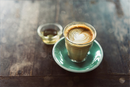 早餐食物咖啡店杯拿铁艺术以木本为背景的绿色碟子图片