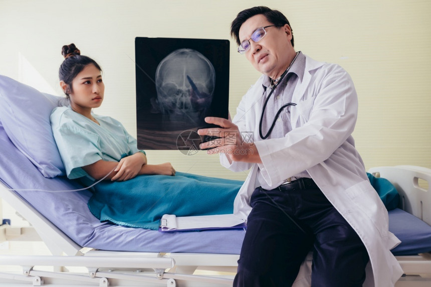 医生向床上的病人解释脑X光检查结果图片