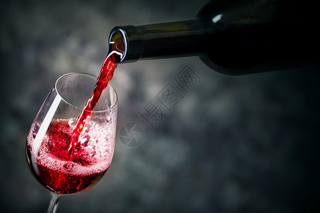 文化存在藤蔓红酒正被倒入黑暗背景的玻璃杯中红酒正被倒入玻璃杯中图片