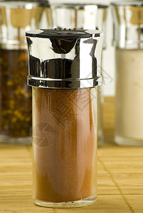 香菜干燥胡椒玻璃罐中的辣粉放在木垫上不同香料背景的玻璃罐中图片