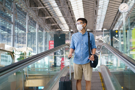 机场戴口罩准备出行的男游客背景图片